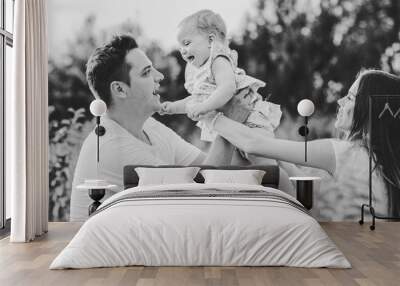 Portrait of a mom, dad and girl playing in the park. Concept of happy family. Black and white photo. Wall mural