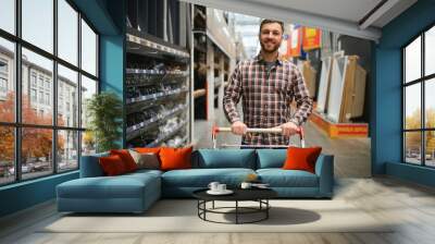 Portrait of happy mature man standing in hardware store Wall mural