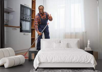 Professional cleaner in blue uniform washing floor and wiping dust from the furniture in the living room of the apartment. Cleaning service concept Wall mural