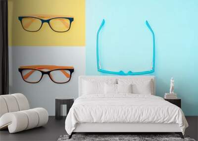 Stylish eyeglasses over background. Optical store, glasses selection, eye test, vision examination at optician, fashion accessories concept. Top view, flat lay Wall mural