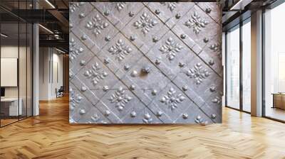 Texture and background of old metal door with patterns, ornaments, and impact handle for opening, Metal plating of the gate in the castle in the middle ages with a picture of a metal eagle with a crow Wall mural