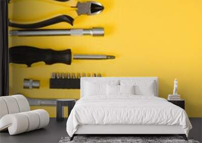 Tools top view on yellow background. Plier, open wrenches, screwdrivers and staple gun flat lay with copy space. Wall mural