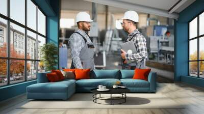 Two engineer worker working together with safety uniform and white helmet to work in industry factory Wall mural