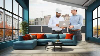 Two multiracial engineer working at site of a large building project. Team of engineer discus at site Wall mural