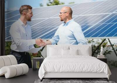 Two people having a shaking hands against solar panel after the conclusion of the agreement in the renewable energy Wall mural