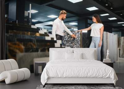 Woman choosing tiles in ceramic and furniture modern shop for her house Wall mural