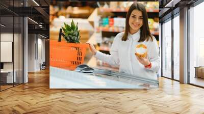 Woman shopping at the supermarket Wall mural