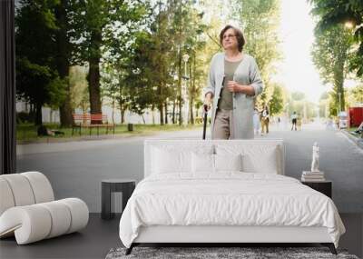 Woman with her walking stick in the park. Wall mural