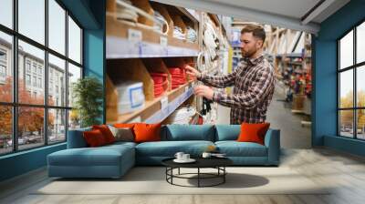 Worker selects an electrical cable at a hardware store Wall mural