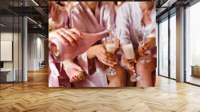 Young bridesmaids clinking with glasses of champagne in hotel room. Closeup photo of cheerful girls celebrating a bachelorette party. Females have toast with wine. Wall mural