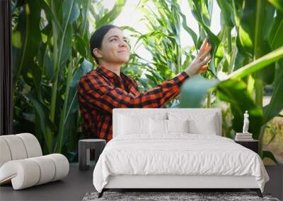 Young female farmer working in the field and checking plants, agriculture and healthy living concept Wall mural