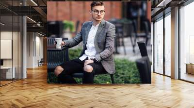 Man sitting on the chair and watching on his watch Wall mural