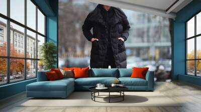 Stylish man wolk on the street. Winter cold outfit. Big jacket with white sneakers. Blured background street. Profecional model photo. Wall mural