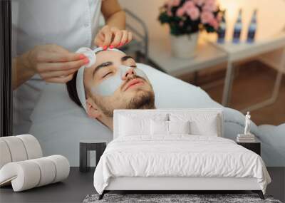 Unshaven man having cosmetic mask care in spa salon, side, top view - Image Wall mural