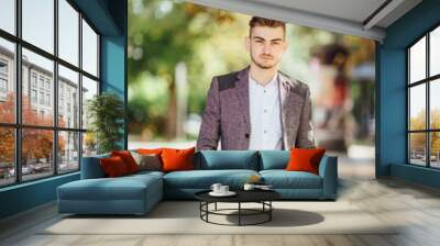 Young man walking on the street with blur background Wall mural