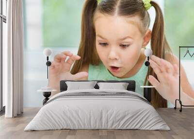 cute little girl is eating green grapes Wall mural