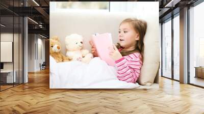 Little girl is reading a book for her teddy bears Wall mural