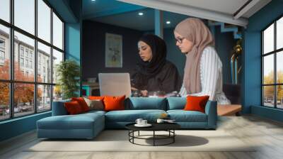 Beautiful two girls with hijab hanging out, typing on laptop, learining about photography and study Wall mural