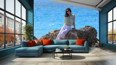 beautiful brunette woman in trousers relaxing on the sea Wall mural