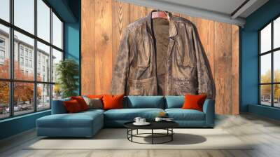 old brown leather jacket on a hanger on a wooden wall Wall mural