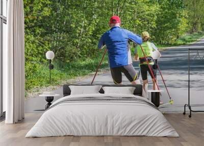 Father and daughter training on the roller skaters. Wall mural