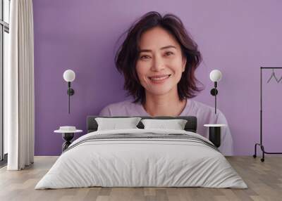 A woman with short hair and a purple shirt is smiling. She is wearing a white shirt underneath her purple shirt Wall mural