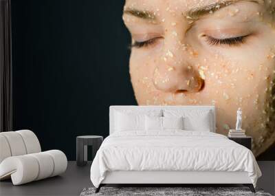 Face of girl with cosmetic mask of oatmeal with honey. Prevention of acne in adolescents. Woman's face with her eyes closed on dark background. Wall mural