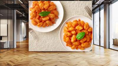 Two white plates of freshly prepared POTATO GNOCCHI in tomato sauce and forks. Marble stone background. View from above. Wall mural