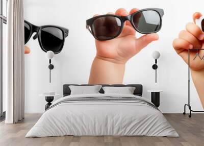 A set of children's hands holding sunglasses isolated on a white or transparent background. Close-up of black and white glasses in hands. Rest, holidays, sun protection. Vacation and travel concept. Wall mural