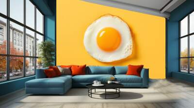 Fried egg isolated on yellow background. Top view Wall mural