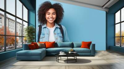 Portrait smiling african student girl wearing jeans jacket isolated on blue background Wall mural