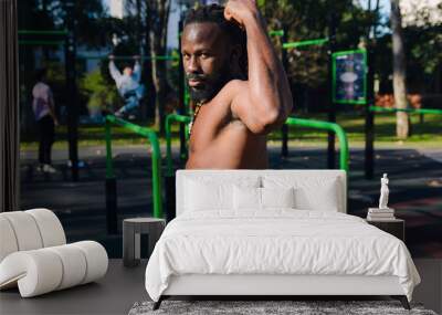 Side view of black Man looking at camera posing showing his strength Wall mural