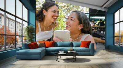 two women mother and daughter happy smiling watching social networks on the phone Wall mural