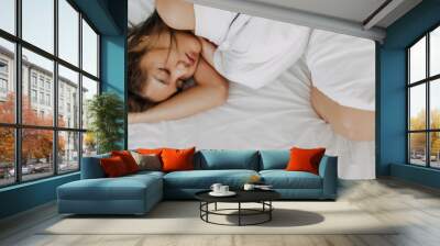 Asian woman sleeping on white bed in concept of tried and drunk morning. Wall mural