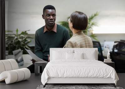 : Portrait of African-American man talking to female manager while working in office, copy space Wall mural