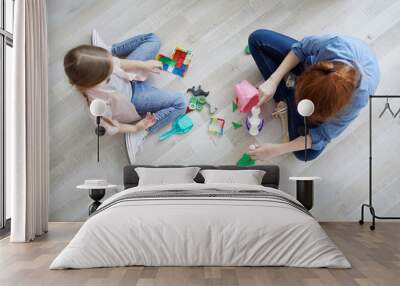 Above view portrait of two sisters playing with puzzles sitting on floor at home, copy space Wall mural