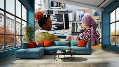 Back view at two female programmers writing code and discussing project together Wall mural