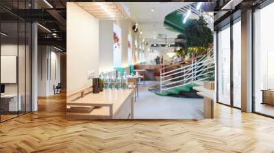 Background image of eco friendly cafe interior with focus on spiral staircase decorated by green plants, copy space Wall mural