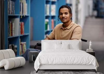 Black young man with disability in library at modern college Wall mural