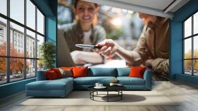 Close up of modern young woman pointing at laptop screen during business meeting in cafe with female colleague, copy space Wall mural