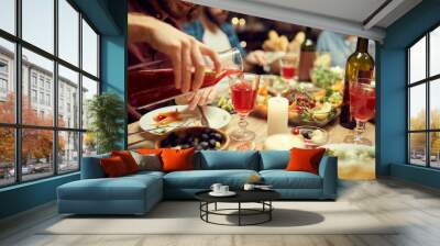 Close up of unrecognizable man pouring raspberry lemonade into glass during dinner party, copy space Wall mural