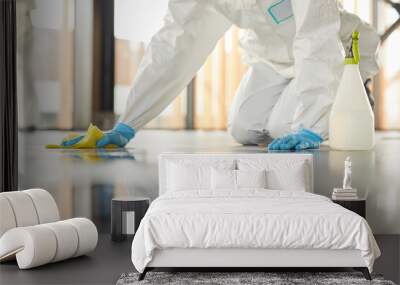 Close up of unrecognizable worker wearing protective suit cleaning floor with chemicals during disinfection indoors, copy space Wall mural