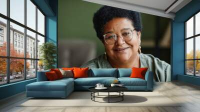 Close up portrait of kind black senior woman smiling at camera at home, copy space Wall mural