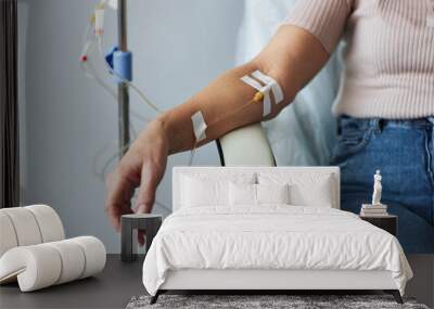 Closeup of female hand with IV drip infusion in treatment session at hospital, copy space Wall mural