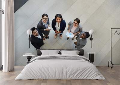 Directly above view of happy confident young multi-ethnic business professionals in formal suits standing in hall of company and smiling at camera Wall mural