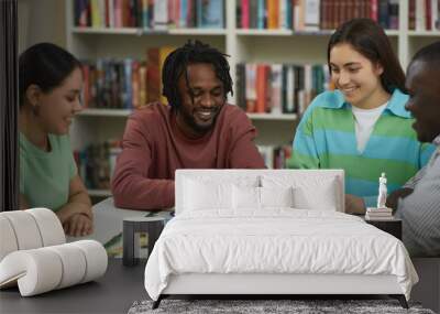 Diverse group of young people playing board games together in library and smiling Wall mural