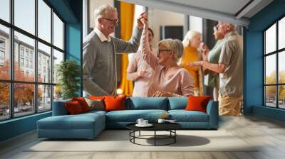 Group of smiling senior people dancing while enjoying activities in retirement home, copy space Wall mural