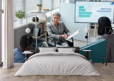 High angle portrait of senior businesswoman using wheelchair while giving presentation in office Wall mural