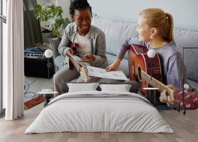 High angle portrait of two young woman playing guitars together and composing song music Wall mural