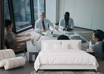 High angle view at group of doctors sitting at meeting table in conference room during medical seminar, copy space Wall mural